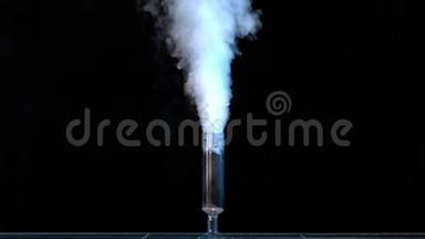 在<strong>化学</strong>实验室<strong>的</strong>一张桌子上测量带有烟雾<strong>的</strong>玻璃。 装有<strong>化学</strong>物质<strong>的</strong>玻璃瓶和黑暗<strong>中的</strong>干冰